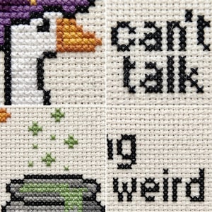 May include: A cross-stitch embroidery on white Aida fabric featuring a white goose with an orange beak and purple hat, a grey cauldron with green liquid, small green stars, and the black stitched text can't talk, big weird.
