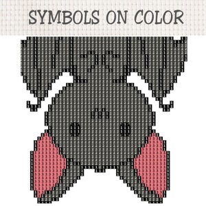 May include: A cross stitch pattern on white fabric featuring a bat design with the text SYMBOLS ON COLOR at the top. The bat is composed of a grid of squares filled with the numbers 1, 2, and 3, representing different colors for the embroidery.