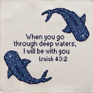 May include: A square cross-stitch embroidery on off-white fabric featuring two dark blue whale sharks with white spots. The text in the centre reads: When you go through deep waters, I will be with you Isaiah 43:2, stitched in dark blue thread.
