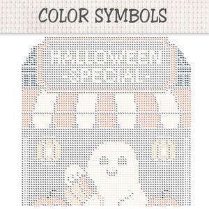 May include: A cross stitch pattern chart titled COLOR SYMBOLS featuring a HALLOWEEN SPECIAL sign, a striped awning, two pumpkins, and a central ghost figure. The design uses a grid of small symbols in shades of orange, black, and white on a fabric background.