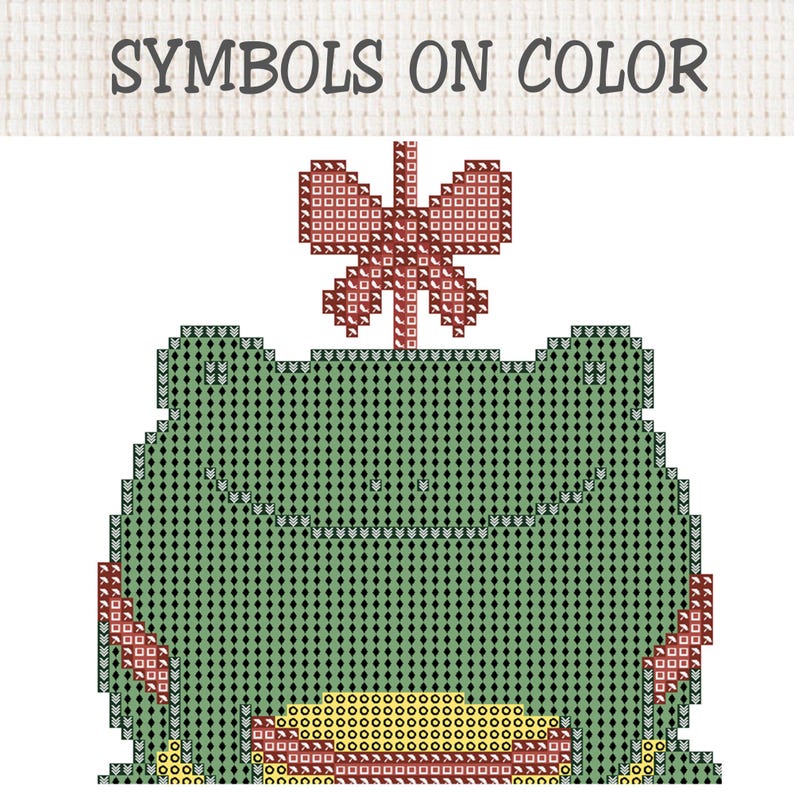 May include: A cross-stitch pattern featuring a green frog with a red butterfly on its head and a yellow belly. The design is composed of various geometric symbols on a grid, with the text SYMBOLS ON COLOR displayed at the top of the image.