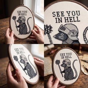 May include: An oval embroidery hoop containing a cross-stitch design on cream fabric. The design features a grey rat wearing a knight's helmet and holding a spiked mace, with the black text "SEE YOU IN HELL" stitched above the figure.