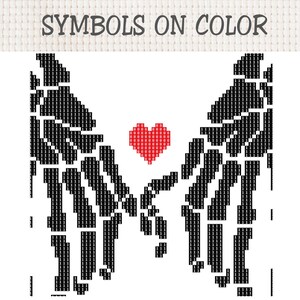 K&ouml;nnte beinhalten: Ein Kreuzstichmuster mit der &Uuml;berschrift SYMBOLS ON COLOR zeigt zwei schwarze Skeletth&auml;nde, die sich mit ber&uuml;hrenden Fingern entgegenstrecken. Ein kleines rotes Herz aus Rasterquadraten befindet sich zwischen den H&auml;nden. Das Design verwendet schwarze Einsen f&uuml;r die H&auml;nde und rote Achten f&uuml;r das Herz.