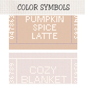 May include: A cross stitch pattern chart on white Aida cloth featuring the text PUMPKIN SPICE LATTE in white block letters against a tan grid background. The design includes a border of small brown hearts and repeating orange leaf motifs.