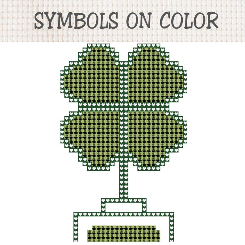 May include: A cross-stitch pattern featuring a four-leaf clover shape filled with small black coffee cup icons on a light green background. The border consists of white heart outlines on a dark green grid. The text SYMBOLS ON COLOR is at the top.