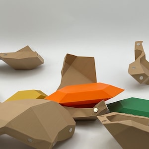 Pu&ograve; includere: Un set di forme geometriche in plastica marrone, arancione, gialla e verde. Le forme sono progettate per incastrarsi come un puzzle.