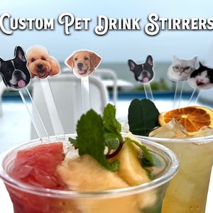 May include: Clear acrylic drink stirrers featuring custom pet face cutouts, including dogs and cats. The text "CUSTOM PET DRINK STIRRERS" is displayed at the top. These stirrers are placed inside two plastic cups filled with fruit-infused beverages.