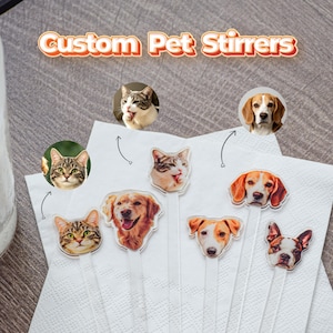 May include: A collection of clear drink stirrers featuring custom printed pet faces, including various cats and dogs. The text Custom Pet Stirrs is displayed at the top. Each stirrer has a long, thin, transparent handle and a die-cut pet portrait.