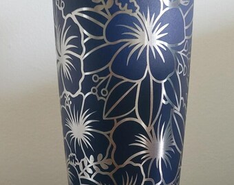May include: A stainless steel tumbler with a navy blue exterior and a silver floral design. The tumbler has a lid.