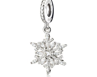 May include: A silver-toned snowflake charm featuring clear, marquise-cut and round-cut cubic zirconia stones. The bail is engraved with the text ATHERAJE and S925, and features a repeating heart pattern along the outer edge of the metal loop.