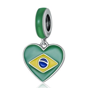 Op de afbeelding: Een zilveren bedel met een groene emaille band en een hartvormige hanger. De hanger heeft het Braziliaanse vlagontwerp in groen, geel en blauw. De bedel is ontworpen om aan een armband of ketting te worden toegevoegd.