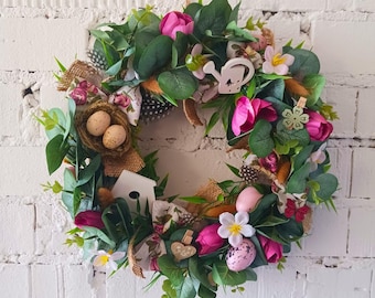 Preciosa corona de Pascua de flores artificiales hechas a mano para la decoración del hogar en primavera.