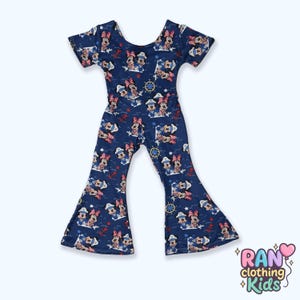 May include: A navy blue jumpsuit with a pattern of Minnie Mouse in sailor outfits, anchors, and nautical elements. The jumpsuit has short sleeves and flared legs. The text "RAN clothing Kids" is in the bottom right corner.