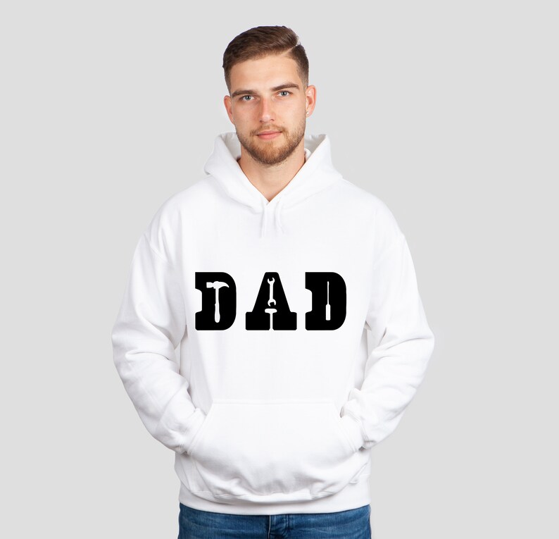Puede incluir: Sudadera con capucha blanca con la palabra "DAD" impresa en negro, con un martillo, una llave inglesa y un destornillador reemplazando las letras "D", "A" y "D".