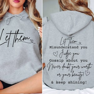 May include: Gray hooded sweatshirt with the text "Let Them Misunderstand You Judge You Gossip About You Never Doubt Your Worth Or Your Beauty! & Keep Shining!" printed on the back.