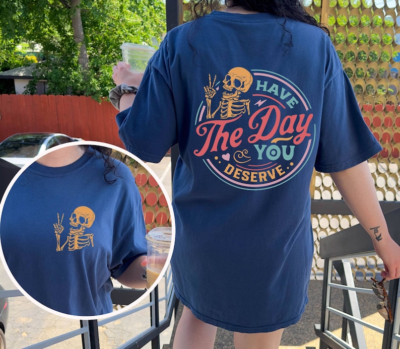 May include: A navy blue t-shirt with a skeleton graphic and the text "Have the Day You Deserve".