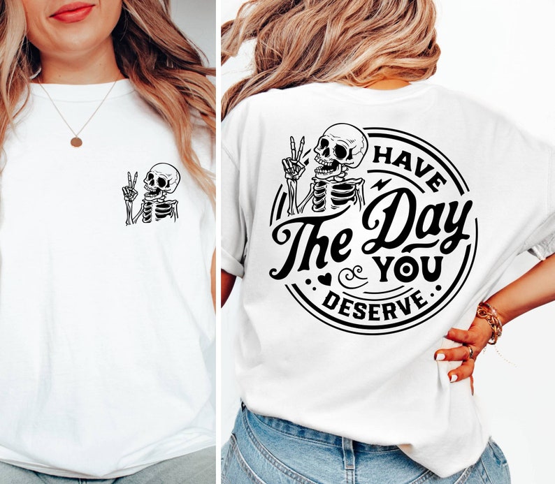 May include: White t-shirt with a black skeleton graphic on the front and a black graphic on the back that says "Have the Day You Deserve" with a skeleton graphic.