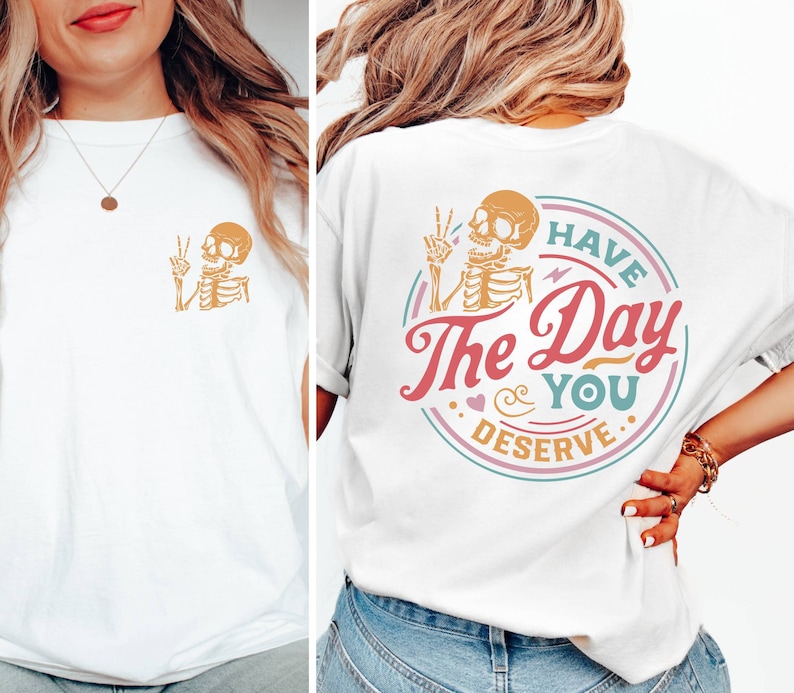 May include: White t-shirt with a skeleton graphic on the front and a graphic on the back that says "Have the Day You Deserve" with a skeleton graphic.