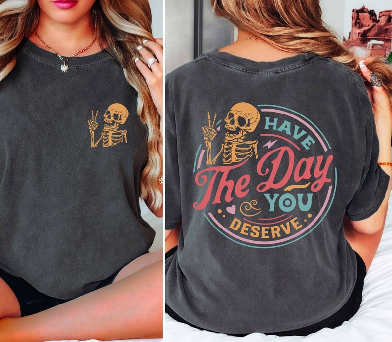 May include: Black t-shirt with a skeleton graphic on the front and a colorful graphic on the back that says "Have the Day You Deserve".