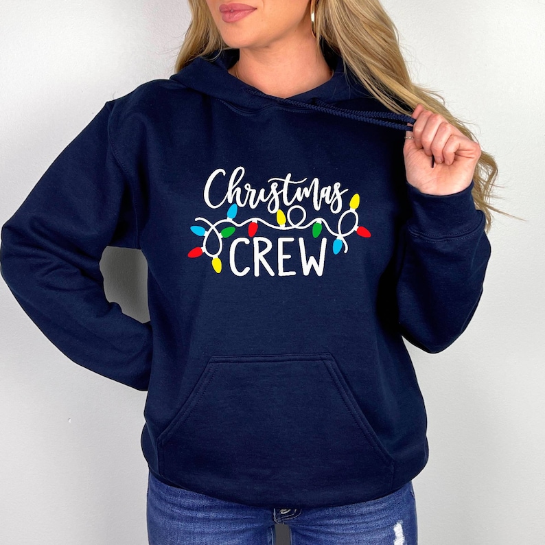 May include: Navy blue hoodie with a white graphic of Christmas lights and the text "Christmas Crew".