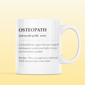Op de afbeelding: Witte keramische mok met een zwart-witte definitie van het woord "Osteopaat" met de fonetische uitspraak en een humoristische beschrijving van het beroep.