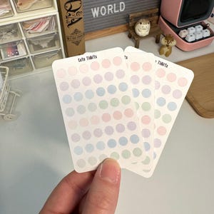 May include: Three sheets of pastel colored dot stickers with the text "Cute Tidbits" on one sheet. The stickers are in shades of blue, green, and pink.