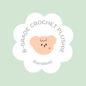 May include: White flower-shaped sticker with the text "B-Grade Crochet Plushie Random!" and a cartoon bear with a pink heart on its cheek.