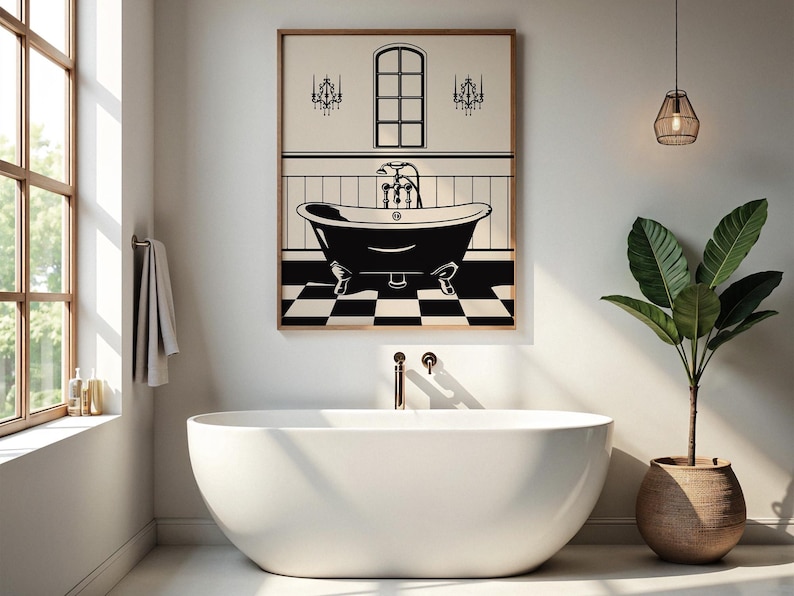 May include: A black and white illustration of a bathtub with a faucet and two chandeliers above it. The illustration is framed and hanging on a white wall in a bathroom with a white freestanding bathtub and a potted plant.