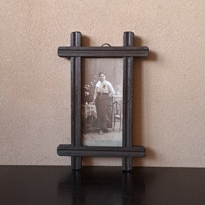 Small antique carved wall mounted photo frame with a photo of a woman