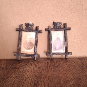 Un par de pequeños marcos verticales de pared para fotos/imágenes, antiguos, de madera tallada con motivos de vagabundos.
