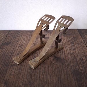 葉のような緑青を帯びたアールヌーボー様式の金属製カーテンレールホルダーのペア