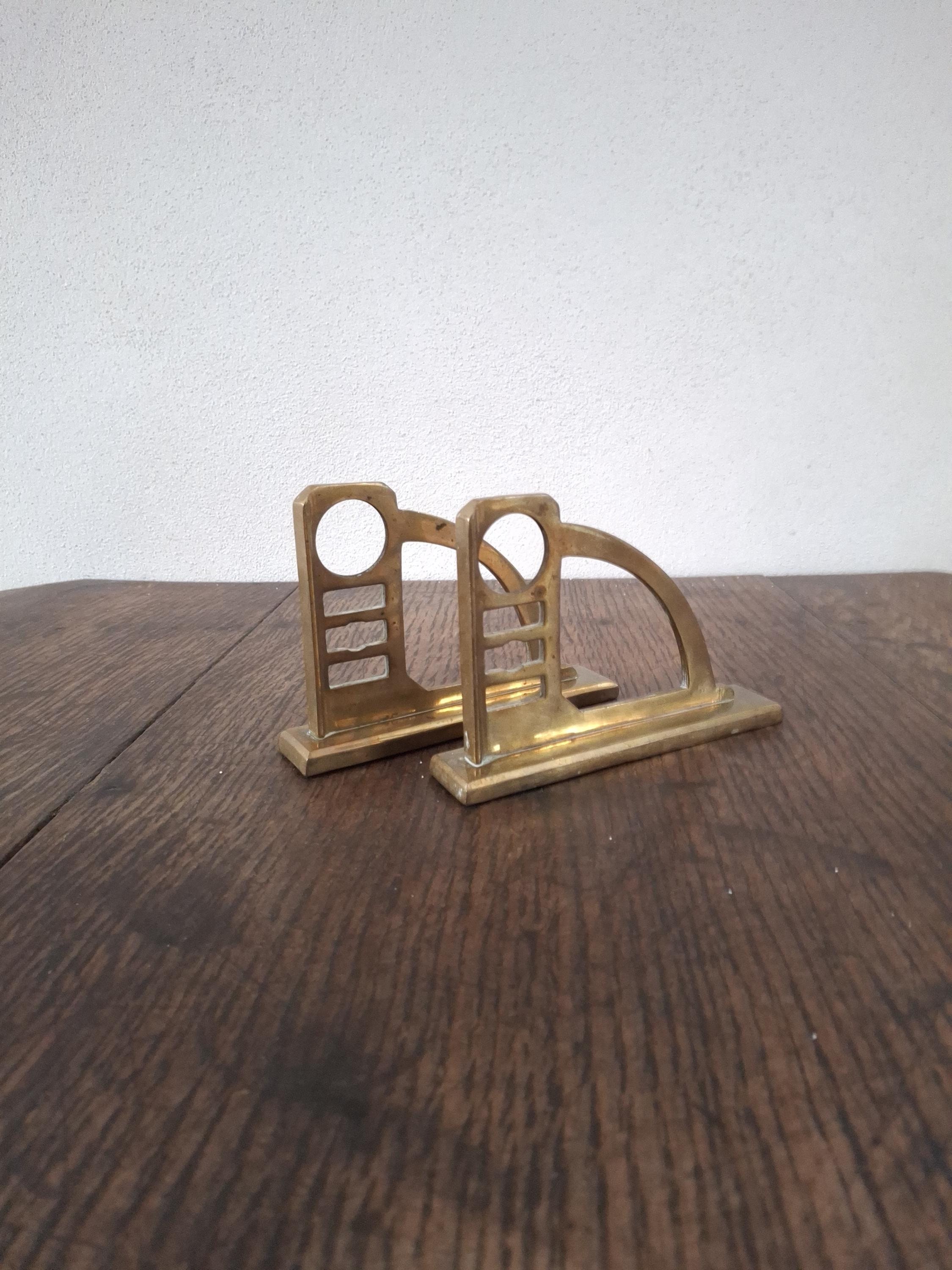 A pair of sturdy Art Nouveau/Art Deco geometrical bronze curtain rod holders