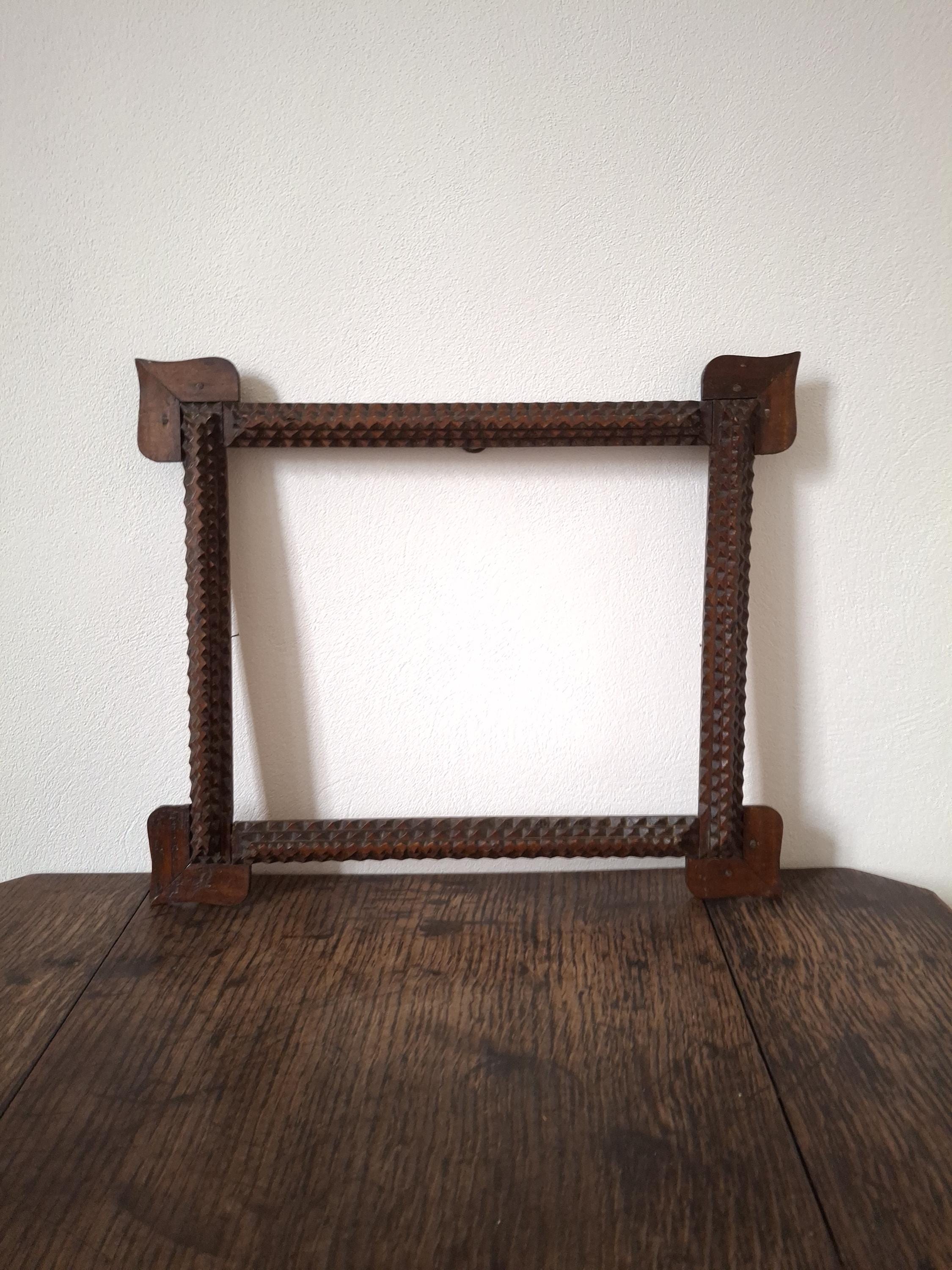 Antique mid-sized horizontal tramp art carved lacquered wooden picture frame