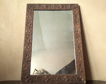 Mid-sized beautifully distressed and foxed antique carved wall mounted mirror frame with an antique silver mirror plate