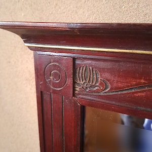 Art Nouveau antique carved horizontal wooden faceted mirror in brownish red