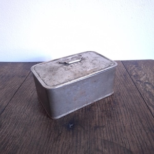 Antike einfache gealterte kleine Metallbox mit einem Klappdeckel und einem Griff