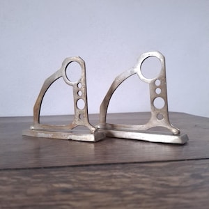 A pair of sturdy Art Deco geometrical bronze curtain rod holders