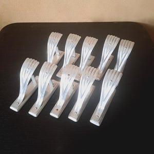 Five pairs of art deco lightweight aluminum curtain rod holders