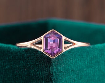 Op de afbeelding: Een ring van roségoud met een zeshoekige zetting met een paarse amethist edelsteen.
