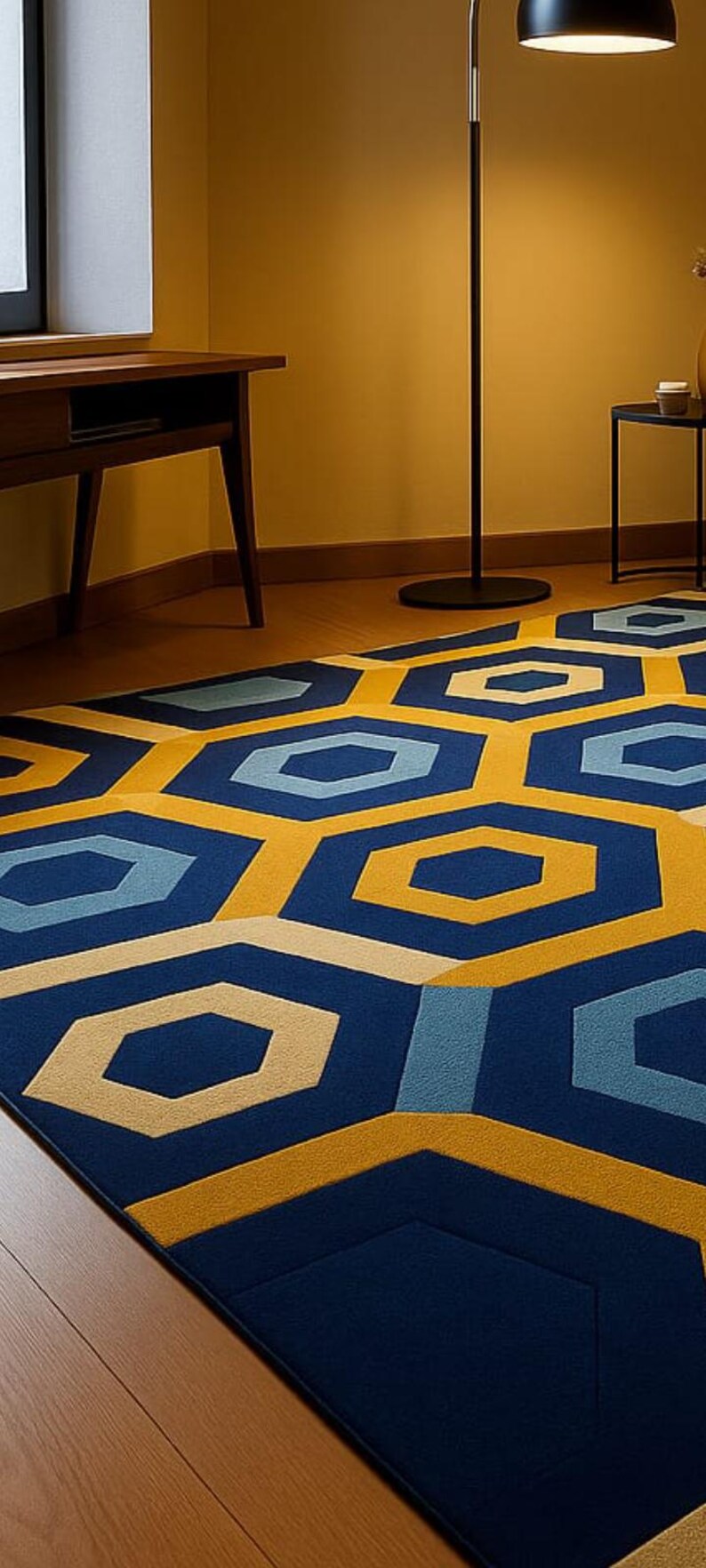May include: A geometric patterned rug with a modern design. The rug features a repeating pattern of blue, yellow, and light blue hexagons. The rug is placed on a wooden floor, and the room has yellow walls.