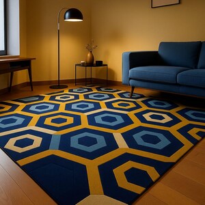 May include: A large area rug with a geometric pattern of navy blue, light blue, and yellow hexagons. The rug is placed on a wooden floor in a room with yellow walls and a blue sofa. The rug's design adds a modern touch to the room's decor.