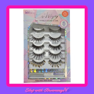 Peut inclure: Un paquet de faux cils KISS So Wispy. L'emballage comprend cinq paires de cils, de la colle &agrave; cils et pr&eacute;sente le texte "FULL, BOUNCY VOLUME & CURL". L'emballage est argent&eacute; et blanc avec des accents roses. Le texte "LIMITED TIME ONLY" est &eacute;galement visible.
