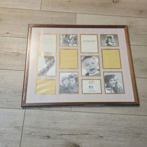 May include: A rectangular brown wooden collage picture frame with a light pink mat board featuring gold-trimmed openings for multiple photos. The frame includes the text INTERCRAFT and measures 16 inches by 20 inches as printed on the label.