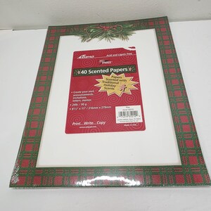 May include: A package of 40 scented papers with traditional holiday scents. The papers are 8.5 x 11 inches and 24lb/90 g. The frame around the papers has a red and green plaid pattern with a decorative sprig of pine and berries.