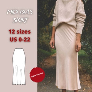 May include: A digital sewing pattern for a midi bias skirt. The pattern includes 12 sizes, US 0-22. The image shows a woman wearing a beige skirt and a white sweater. The skirt is a midi length and has a bias cut. The pattern includes a video tutorial.