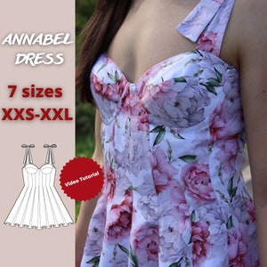 May include: A white dress with a floral print featuring pink and purple flowers. The dress has a sweetheart neckline and a fitted bodice. The dress is available in seven sizes, from XXS to XXL. The image also includes a line drawing of the dress and the text "Annabel Dress" and "Video Tutorial".