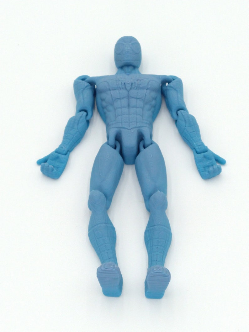 May include: A light blue action figure of a superhero, with articulated joints. The figure is in a standing pose with arms outstretched. The figure has a detailed design, including a mask and textured suit.