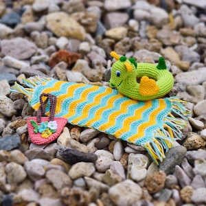 May include: A crocheted beach towel with yellow and blue stripes, a crocheted seahorse float, and a small crocheted bag with pink and white flowers.