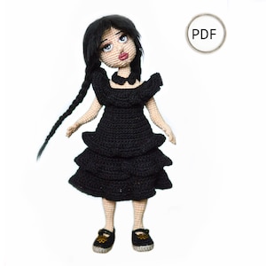 May include: Crochet doll wearing a black dress with a ruffled skirt and black shoes. The doll has long black hair in braids and a white collar.