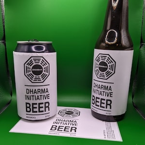 Peut inclure: Deux bouteilles de bière Dharma Initiative, l'une en verre et l'autre en canette, toutes deux avec une étiquette noire et blanche représentant le logo de Dharma Initiative et le texte "Dharma Initiative Beer".
